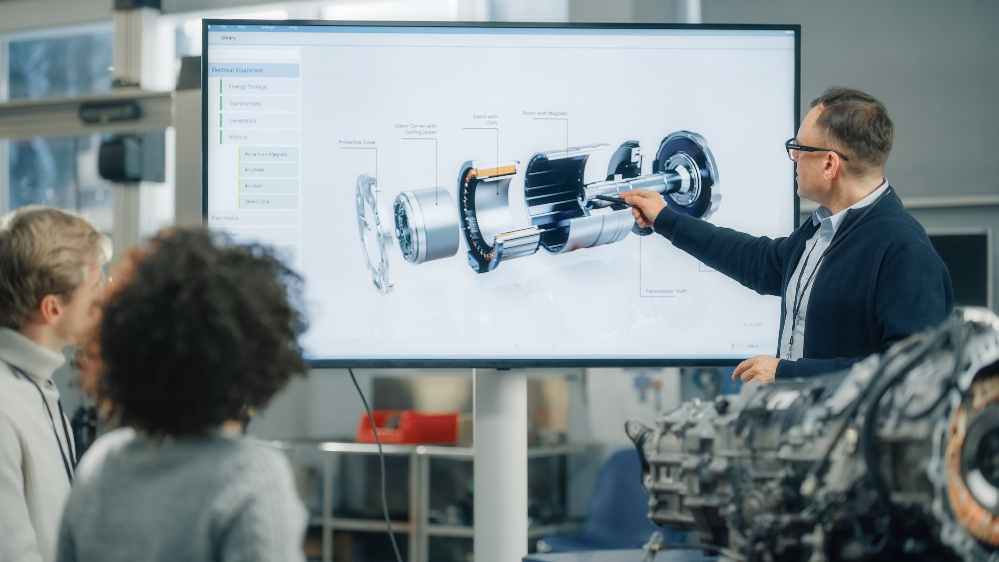 Especialista apresentando estrutura detalhada de um motor elétrico em tela digital durante treinamento técnico